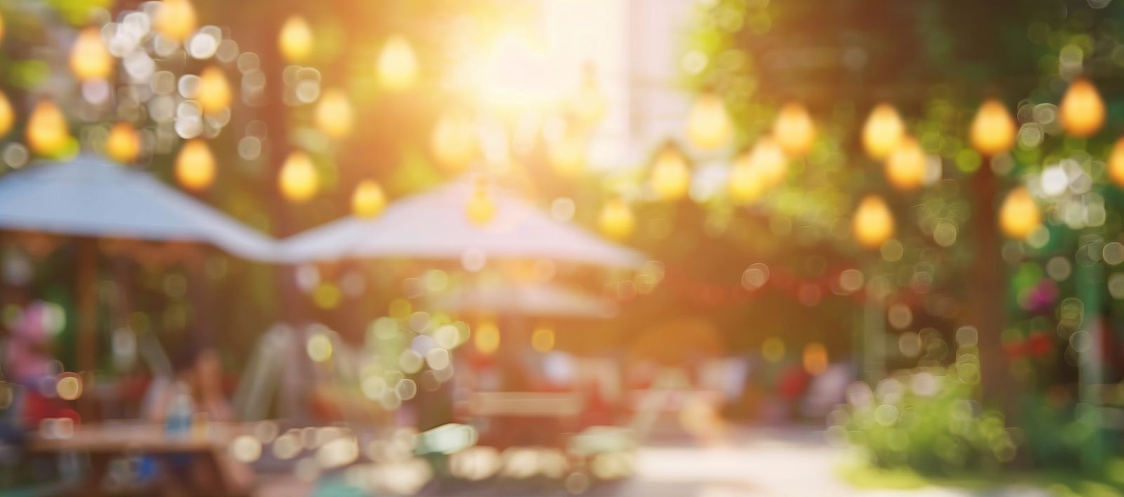 Ein leerer Holztisch bei einer Gartenparty im Sommer, verschwommener Bokeh Hintergrund